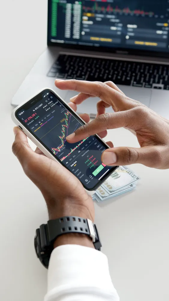 Owner reviewing finances on a phone with cash on the desk